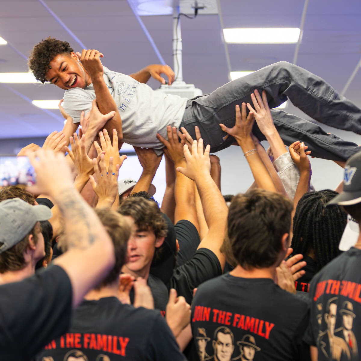 A group of students holding another student up in the air